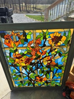 Window panel with orange flowers and green leaves
