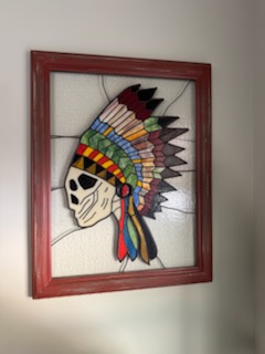 Custom stained glass panel of a feathered headdress in a red frame