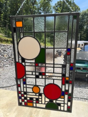 Frank Lloyd Wright style panel with colored circles and rectangles on textured clear glass